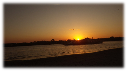 A sunset over a body of water

Description automatically generated