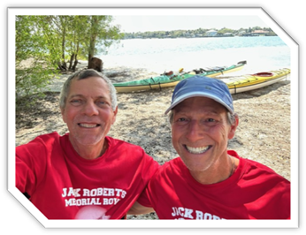 A couple of men smiling

Description automatically generated