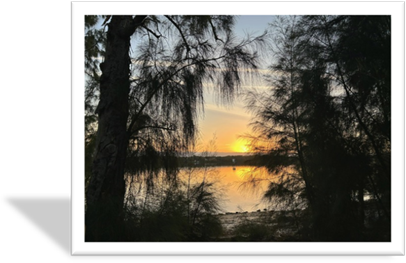 A sunset over a body of water

Description automatically generated