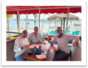 A group of men sitting at a table with drinks

Description automatically generated