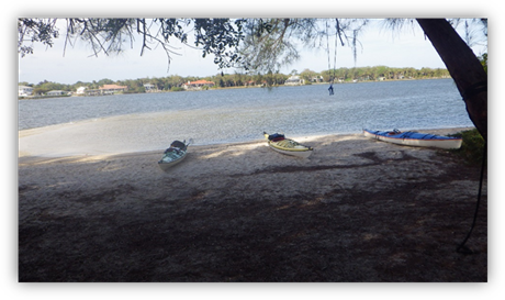 Kayaks on a beach by a body of water

Description automatically generated