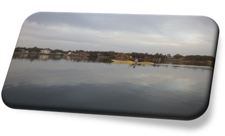 A person in a yellow kayak on a lake

Description automatically generated